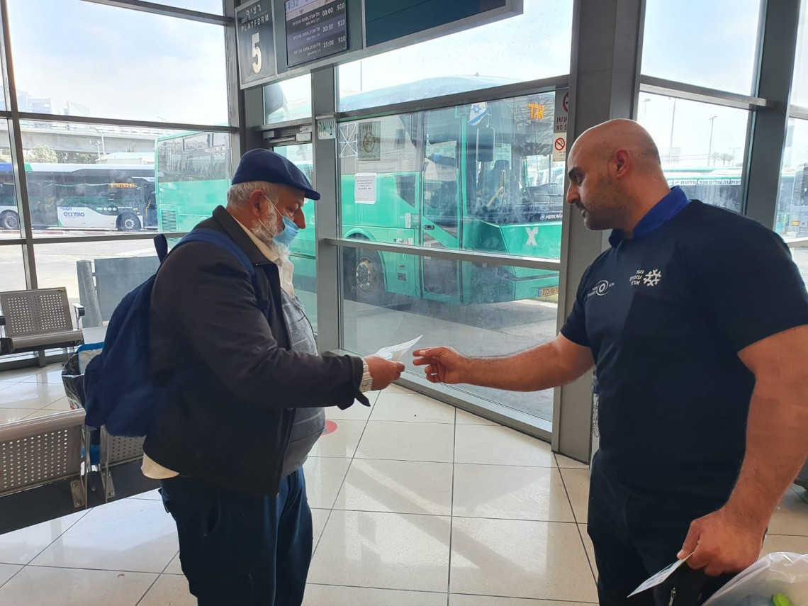 עובד אגד מחלק עלון הסברה לנוסע